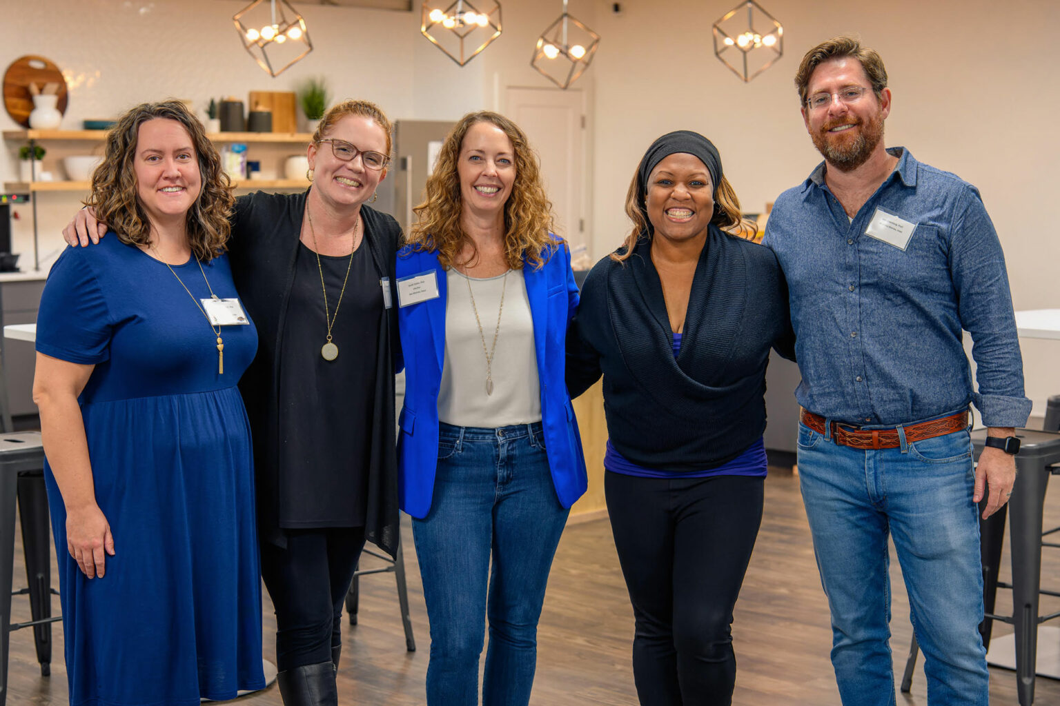 Five members of the Iowa Psychological Association stand together, smiling and showing camaraderie.