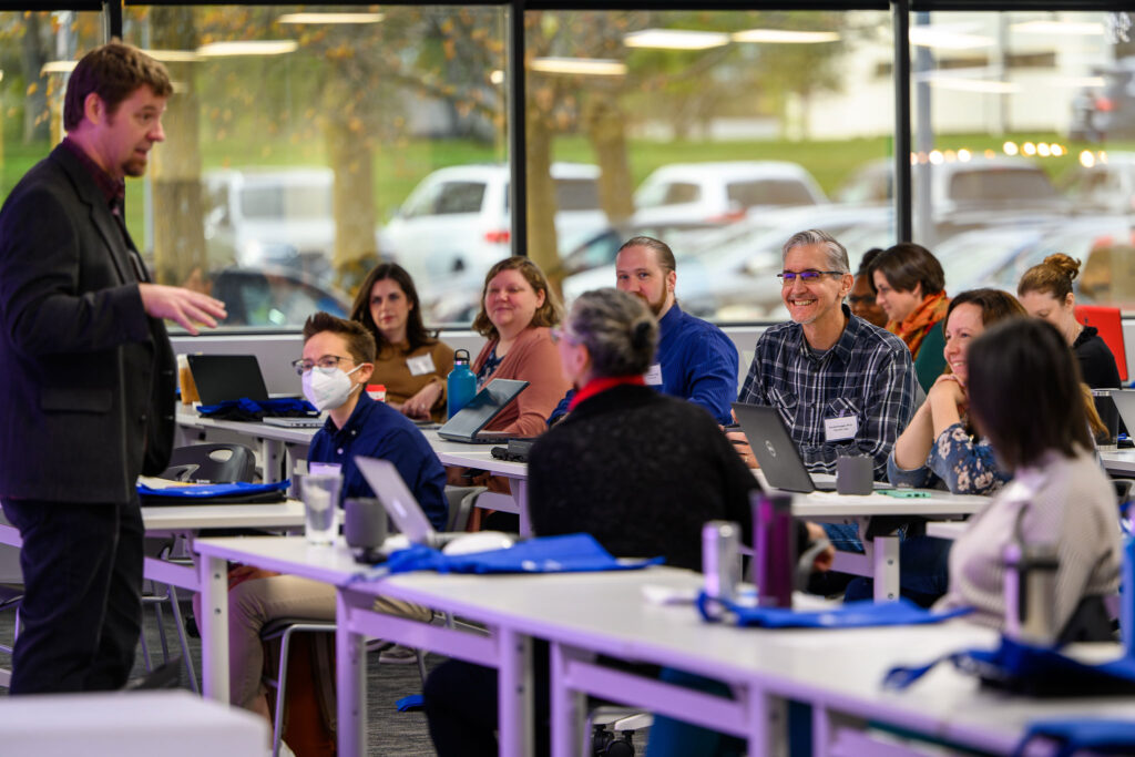 Image of attendees listening to a presenter.